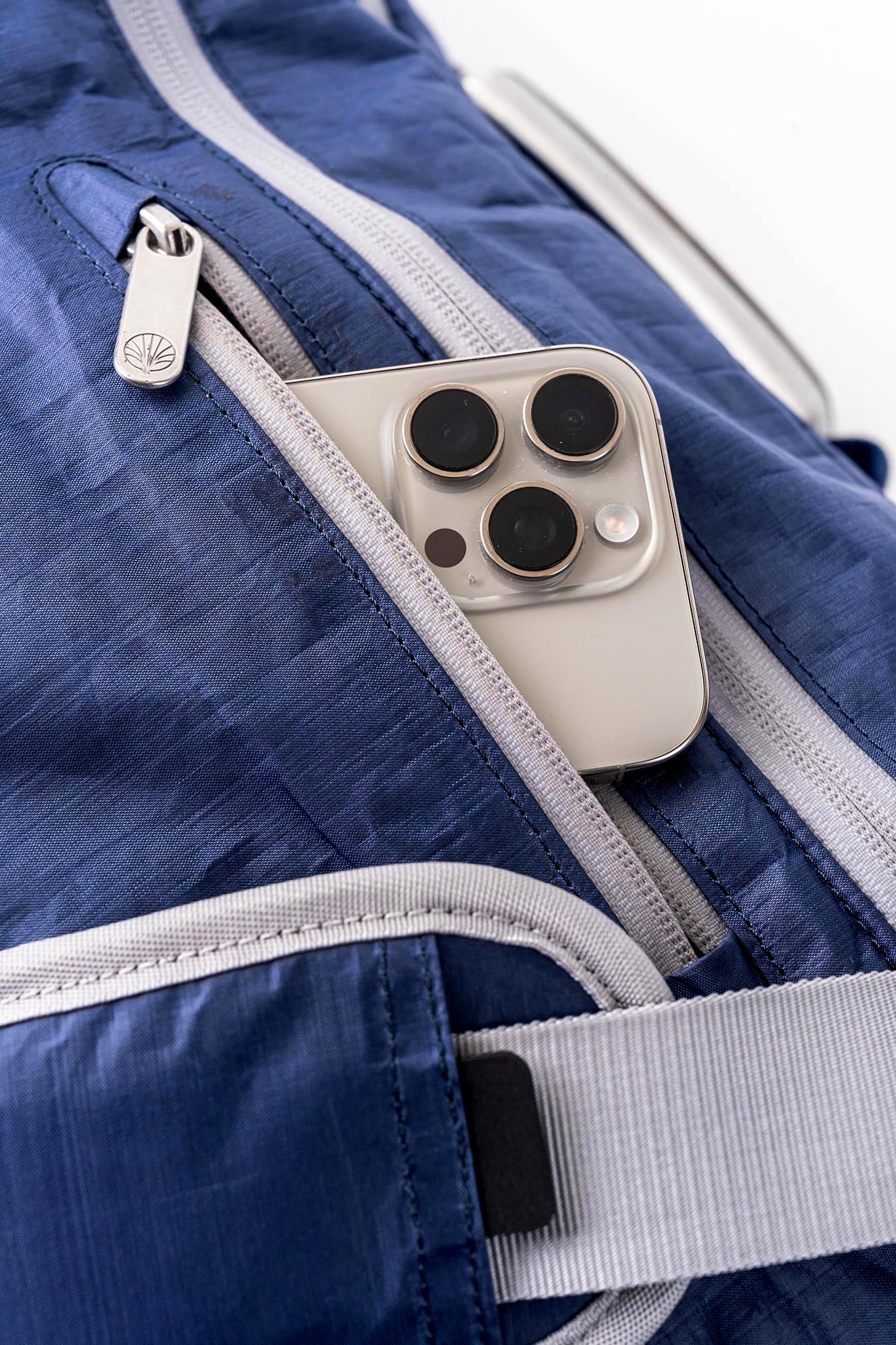 Close-up of the Offsite Work-to-Water Bag in Ocean blue Dyneema, showing fleece-lined quick-access front pocket with smartphone