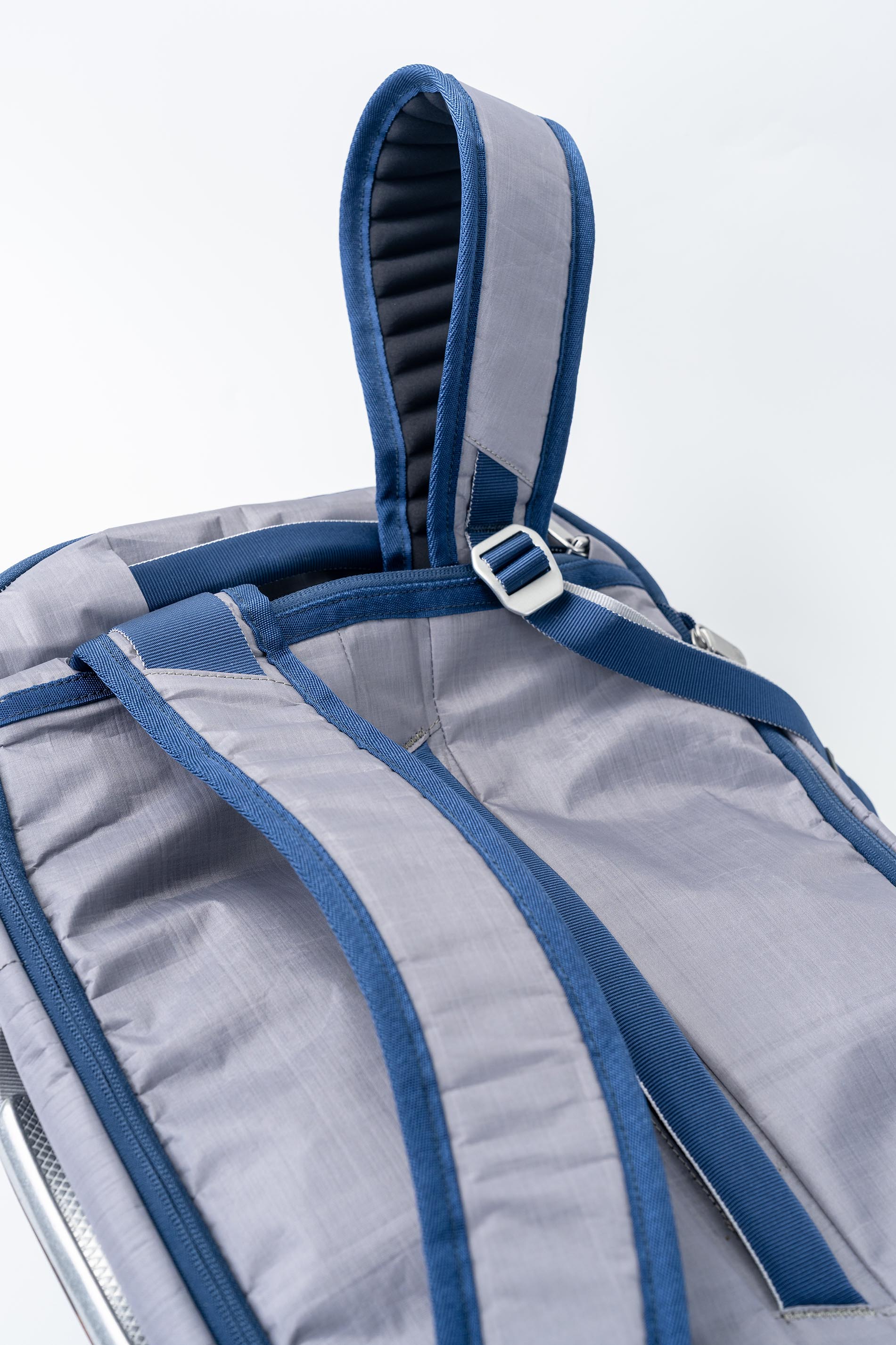 Close-up of a gray and blue backpack with straps on a white background