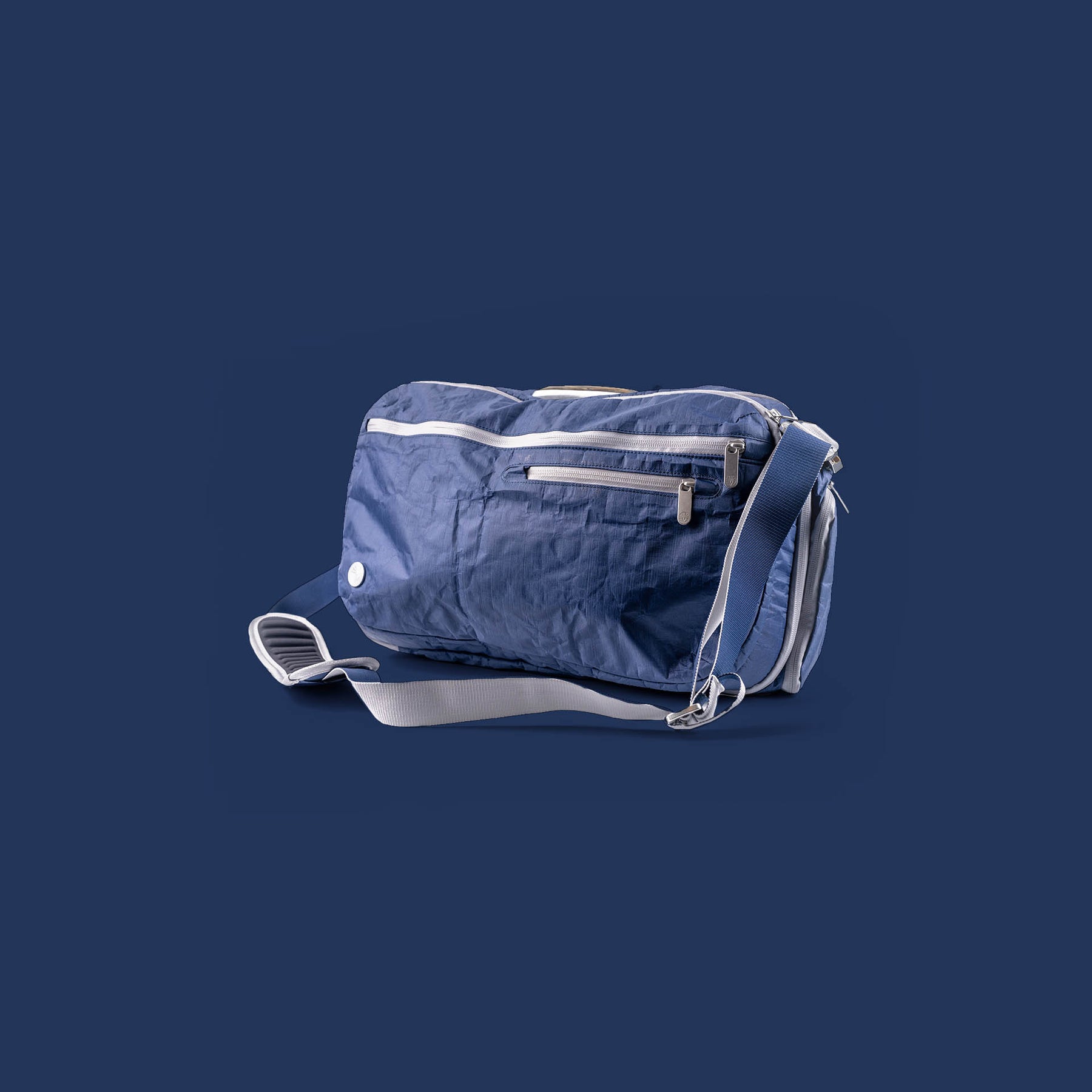 Dark Blue Offsite bag with a strap on a dark blue background
