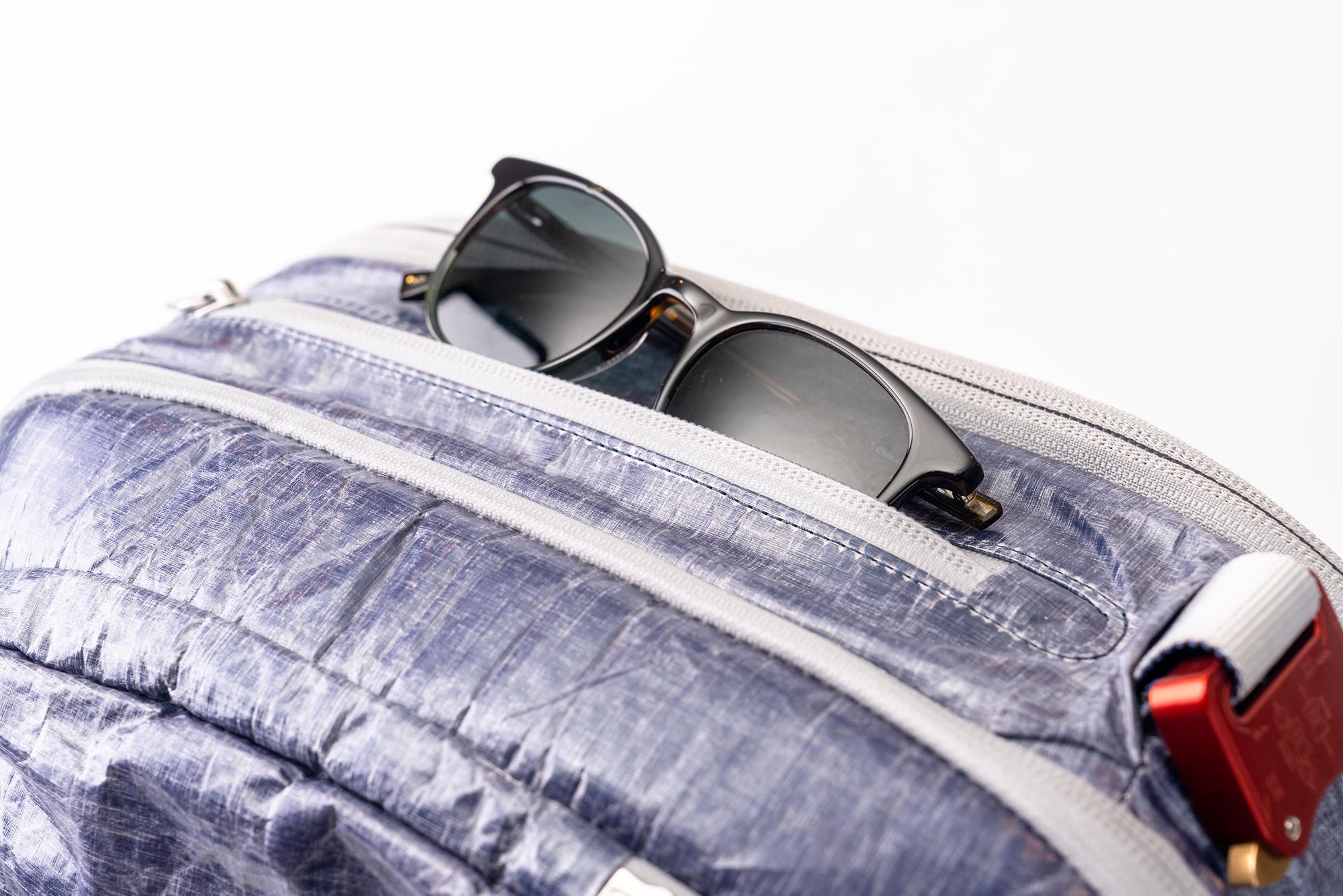 Sunglasses sticking out of pocket on the "White Cap"  Work to Water bag. 