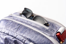 Sunglasses sticking out of pocket on the "White Cap"  Work to Water bag. 
