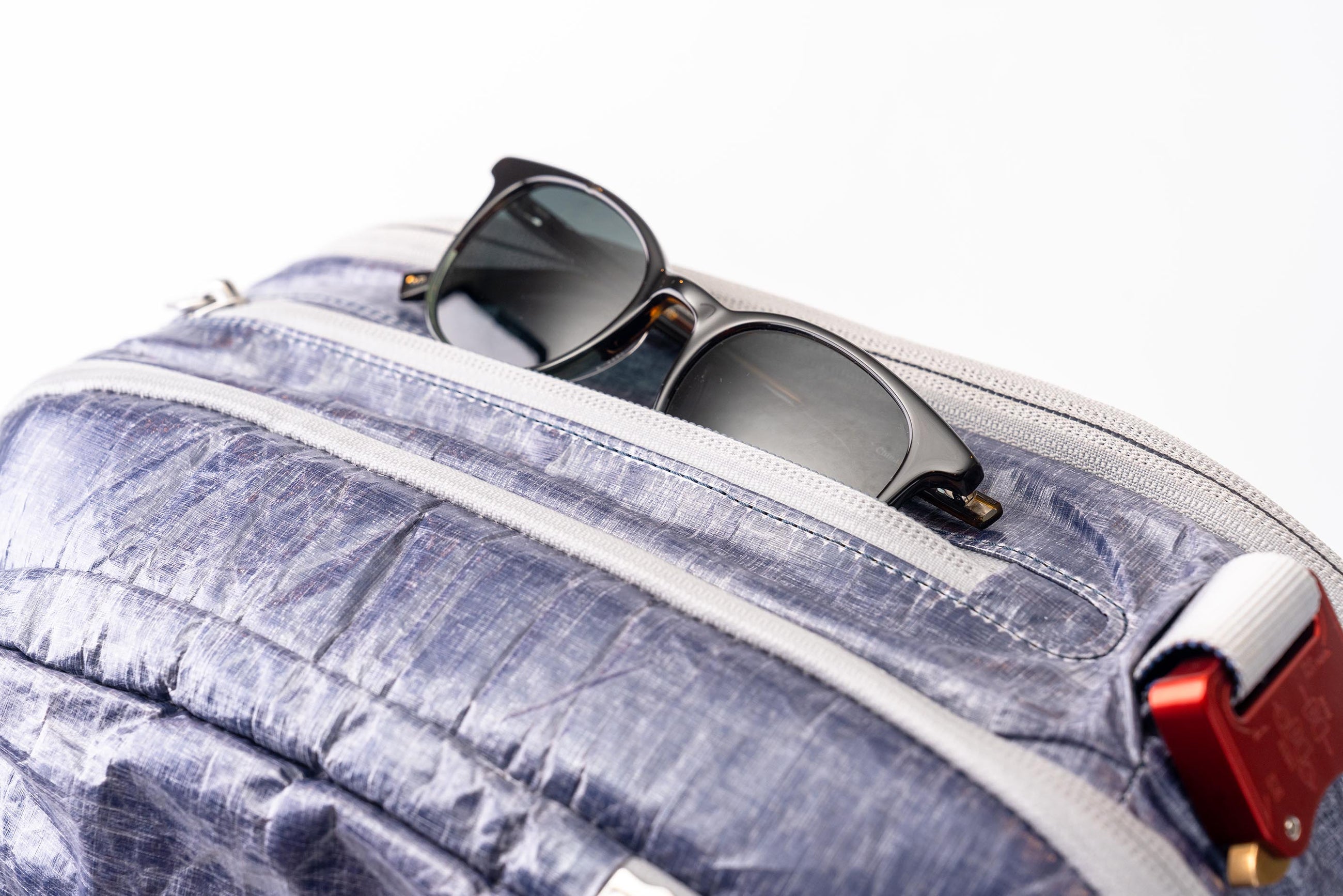 Sunglasses sticking out of pocket on the "White Cap"  Work to Water bag. 