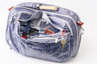 Blue "White Cap" Work to Waterbag with compartments open, revealing items like a passport and keys.