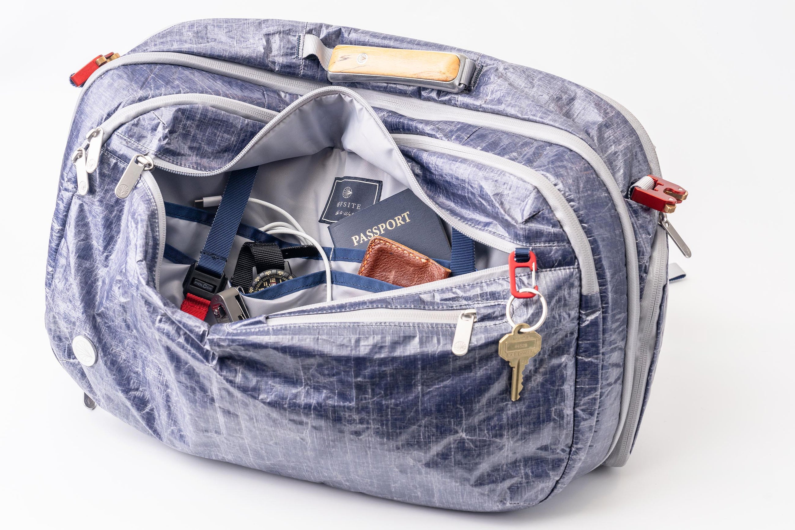 Blue "White Cap" Work to Waterbag with compartments open, revealing items like a passport and keys.