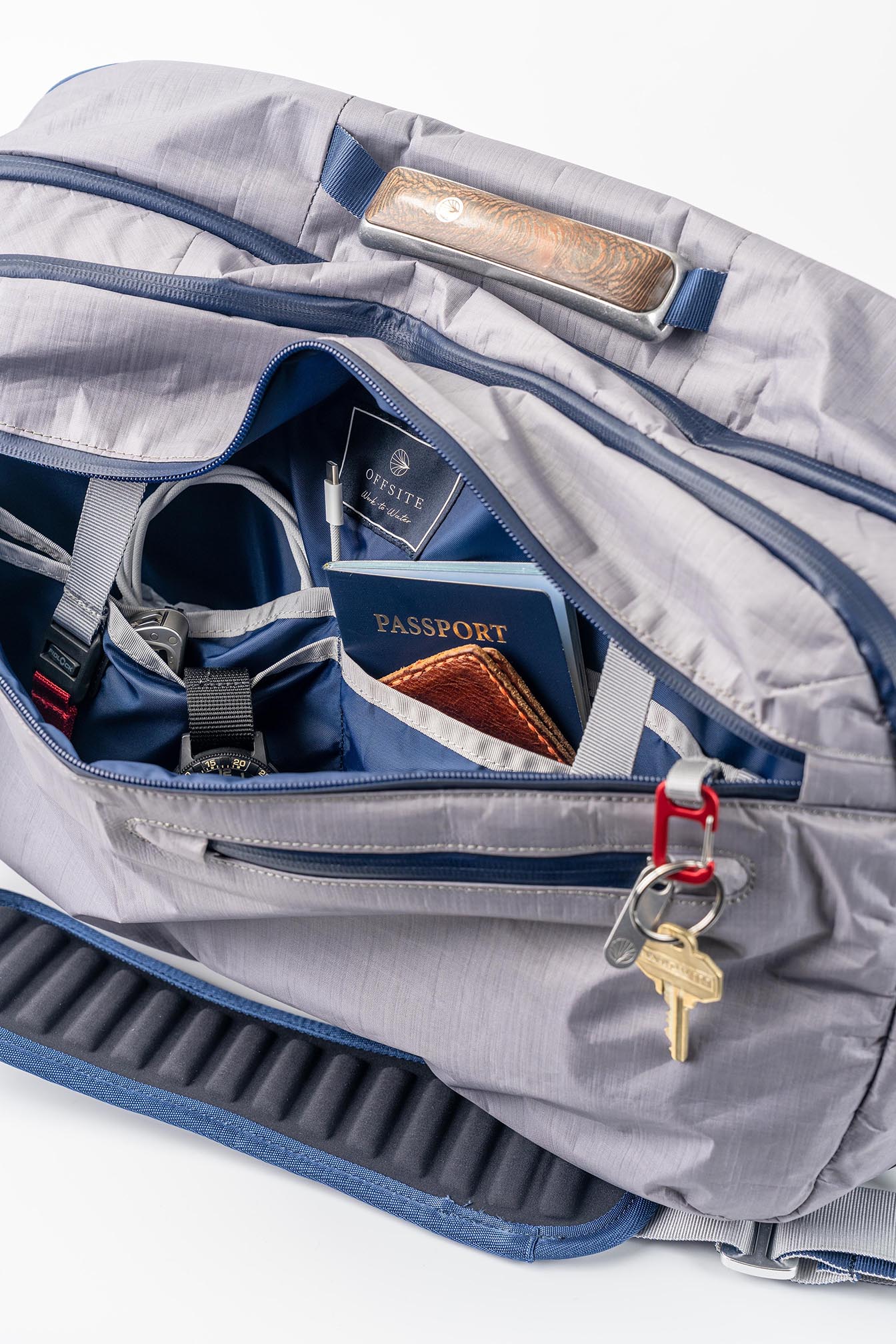 Offsite Work-to-Water Bag in Haze gray with front compartment open, showing organized interior pockets, key lanyard, passport sleeve, and everyday essentials.