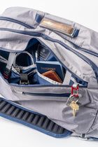 Offsite Work-to-Water Bag in Haze gray with front compartment open, showing organized interior pockets, key lanyard, passport sleeve, and everyday essentials.