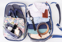 Top-down view of the Offsite Work-to-Water bag fully packed with folded clothing, flip-flops, toiletries, sunglasses, and accessories, demonstrating organized weekender and travel capacity
