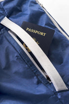 Passport stored in the backside secret quick-access pocket of the Offsite Work-to-Water Bag in Ocean blue just behind the luggage pass thru strap.