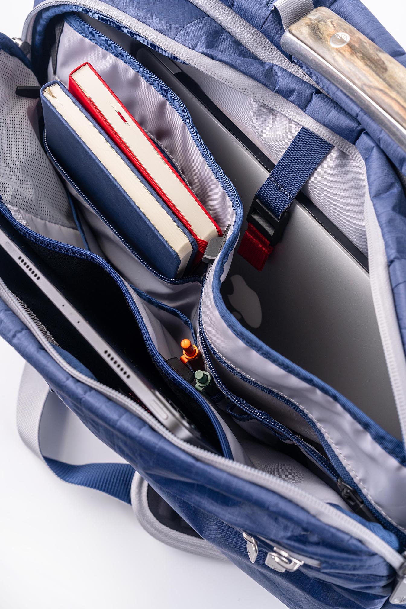 Interior view of the Offsite Work-to-Water Bag in Ocean blue showing padded laptop sleeve, tablet pocket, notebook storage, and organized interior compartments