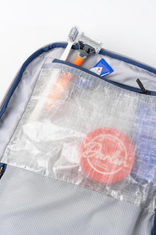 Interior view of the Offsite Work-to-Water bag showing a built-in waterproof Dyneema dopp kit pocket with translucent fabric and zippered closure.
